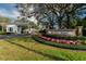 Community entrance featuring stone signage and manicured landscaping with colorful flowers at 8510 Kentucky Derby Dr, Odessa, FL 33556