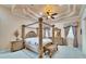 This large bedroom features a four-poster bed, elegant decor, and tray ceiling at 8510 Kentucky Derby Dr, Odessa, FL 33556