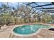 Large screened pool area with spa, offering privacy and views of the landscaped backyard at 8510 Kentucky Derby Dr, Odessa, FL 33556