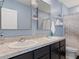 Well-lit bathroom featuring double sinks and black cabinets at 8617 Falling Blue Pl, Riverview, FL 33578