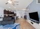 Cozy living room flowing into the kitchen and dining area, with a large TV and comfortable sofa at 8617 Falling Blue Pl, Riverview, FL 33578