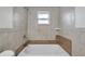 Well-lit bathroom featuring a bathtub with tiled walls and a window at 9013 Tree Valley Cir, Tampa, FL 33615