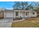 Charming single-story home with a well-maintained lawn and classic architectural details at 9013 Tree Valley Cir, Tampa, FL 33615