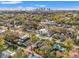 Aerial view of a modern home nestled among lush greenery, with a beautiful cityscape in the distance at 910 W West St, Tampa, FL 33602