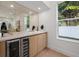 An elegant bar area with a wine cooler, countertop, cabinets, and mirrored wall creating a sophisticated space at 910 W West St, Tampa, FL 33602