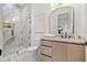 An elegant bathroom features a glass shower, marble tiling, vanity, and a beautifully framed mirror at 910 W West St, Tampa, FL 33602