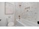 Modern bathroom featuring a white bathtub with mosaic tiling and gold fixtures at 910 W West St, Tampa, FL 33602