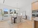 Bright dining room featuring a modern chandelier, six chairs, and three windows overlooking the yard at 910 W West St, Tampa, FL 33602