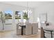 Bright dining room featuring a modern chandelier, six chairs, and three windows overlooking the yard at 910 W West St, Tampa, FL 33602