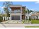 Striking contemporary home with a balcony, wood accents, manicured landscaping and modern driveway at 910 W West St, Tampa, FL 33602