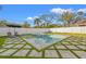 Inviting pool area with a relaxing lounge space and a spa, surrounded by grass pavers and a privacy fence at 910 W West St, Tampa, FL 33602