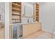 Wet bar featuring wood cabinets, open shelving, and a beverage refrigerator at 910 W West St, Tampa, FL 33602