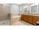 Bathroom featuring double sinks, soaking tub, and glass shower stall at 10063 Celtic Ash Dr, Ruskin, FL 33573