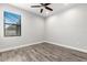 Bedroom showcasing wood-look floors, ceiling fan, and a window allowing natural light at 10063 Celtic Ash Dr, Ruskin, FL 33573