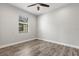 Bedroom with wood-look floors, a ceiling fan, and a window with blinds for natural light at 10063 Celtic Ash Dr, Ruskin, FL 33573