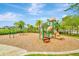 Community playground with swings and slides, featuring a wood-chip ground cover and surrounding green space at 10063 Celtic Ash Dr, Ruskin, FL 33573