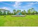 Community playground with slides and climbing structure, set in a green lawn under a blue sky at 10063 Celtic Ash Dr, Ruskin, FL 33573