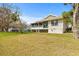 Home's back exterior showcasing screened porch and landscaping at 1007 Lake Avoca Dr, Tarpon Springs, FL 34689