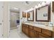 Bright bathroom featuring double sinks, granite countertops, tile floors and glass enclosed shower at 1007 Lake Avoca Dr, Tarpon Springs, FL 34689