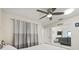 Bedroom featuring ceiling fan, white walls, curtains, large storage closet and adjacent living room at 1007 Lake Avoca Dr, Tarpon Springs, FL 34689