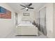 Bedroom featuring ceiling fan, white walls, curtains and stylish patriotic decorations at 1007 Lake Avoca Dr, Tarpon Springs, FL 34689