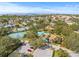 Aerial view of a community featuring tennis courts, swimming pool, and lush landscaping at 1007 Lake Avoca Dr, Tarpon Springs, FL 34689