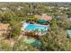 Aerial view showcasing community pool, clubhouse, shuffleboard court and verdant surroundings at 1007 Lake Avoca Dr, Tarpon Springs, FL 34689