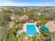 Aerial view of a community pool with ample seating, surrounded by lush landscaping at 1007 Lake Avoca Dr, Tarpon Springs, FL 34689