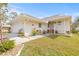 Beautiful single-story home featuring a manicured lawn, and a cozy front porch setting at 1007 Lake Avoca Dr, Tarpon Springs, FL 34689