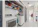 Laundry room featuring front loading washer and dryer, hanging rack, shelving and barn door at 1007 Lake Avoca Dr, Tarpon Springs, FL 34689