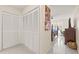 Bright main bedroom hallway featuring storage closet and view to bed, desk and windows at 1007 Lake Avoca Dr, Tarpon Springs, FL 34689