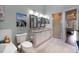 Bright bathroom featuring double vanity, decorative wall art, a walk-in shower and linen closet at 102 Brent Cir, Oldsmar, FL 34677