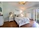 Inviting bedroom with wood floors, white furnishings, and a private balcony view at 102 Brent Cir, Oldsmar, FL 34677