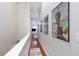 Hallway featuring wood floors, decorative art and access to a bedroom with natural lighting at 102 Brent Cir, Oldsmar, FL 34677