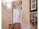 Hallway view featuring pantry door and stairway access with decorative wall art and wood flooring at 102 Brent Cir, Oldsmar, FL 34677