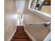 A staircase featuring stained wood steps and a white handrail offers a stylish transition between levels at 102 Brent Cir, Oldsmar, FL 34677