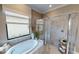 Luxurious bathroom featuring a modern soaking tub, glass-enclosed shower, and stylish decor for a spa-like experience at 11393 Pinot Dr, Venice, FL 34293