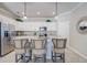 Well-lit kitchen featuring white cabinets, granite counters, stainless steel appliances, and bar stool seating at 11470 Burgundy Dr, Venice, FL 34293