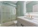 Well-lit bathroom featuring a vanity and bathtub with glass doors at 1440 Harbour Walk Rd, Tampa, FL 33602