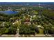 Expansive aerial view of a single-Gathering home nestled among lush trees near a lake on a sprawling lot at 17630 Brown Rd, Odessa, FL 33556