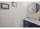 Stylish powder room featuring a navy blue vanity, marble countertop, and gold accents at 17630 Brown Rd, Odessa, FL 33556