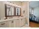 Dual sink bathroom vanity featuring granite counters and bronze fixtures, leading to the main bedroom at 17630 Brown Rd, Odessa, FL 33556