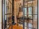 Wine cellar featuring wood paneling, custom shelving, and glass door at 17630 Brown Rd, Odessa, FL 33556