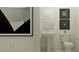 Modern powder room featuring a pedestal sink, toilet, and stylish artwork at 18190 Serene Lake Loop, Lutz, FL 33548