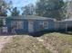 Exterior of a single-story home with a blue exterior and a yard in need of landscaping at 1911 E Noel St, Tampa, FL 33610