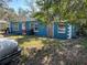 Side angle view of the blue home showing the yard, windows and front door at 1911 E Noel St, Tampa, FL 33610