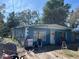 Side angle view of the blue home showing the yard, windows and front door at 1911 E Noel St, Tampa, FL 33610