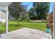 This back patio features concrete tiling that overlooks a wide-open lawn and beautiful trees at 2075 Lakewood Club S Dr # 6A, St Petersburg, FL 33712