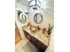 Bathroom sink with brown cabinets, a decorative round mirror, and tan countertop at 2172 University S Dr, Clearwater, FL 33764