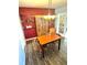 Dining room features vintage chandelier, wood table, and decorative shelving against a red accent wall at 2172 University S Dr, Clearwater, FL 33764